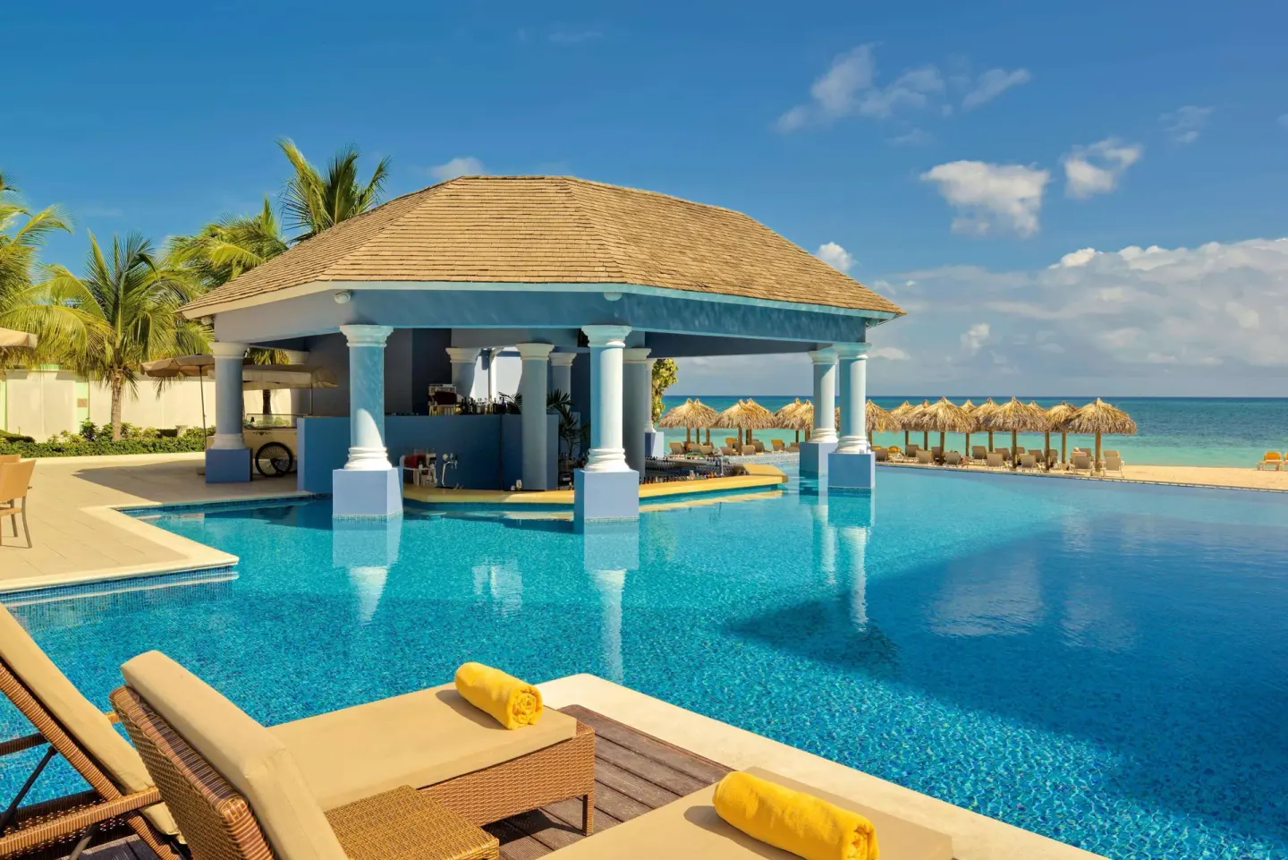 Pool bar pavilion beside the ocean at JOIA Rose Hall by Iberostar.