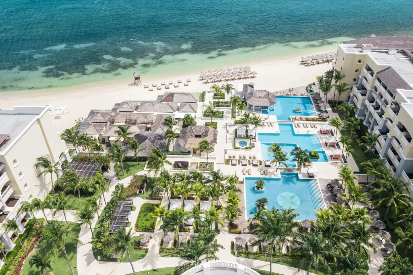 Overhead view of pools, gardens, beach, and resort buildings at JOIA Rose Hall by Iberostar.