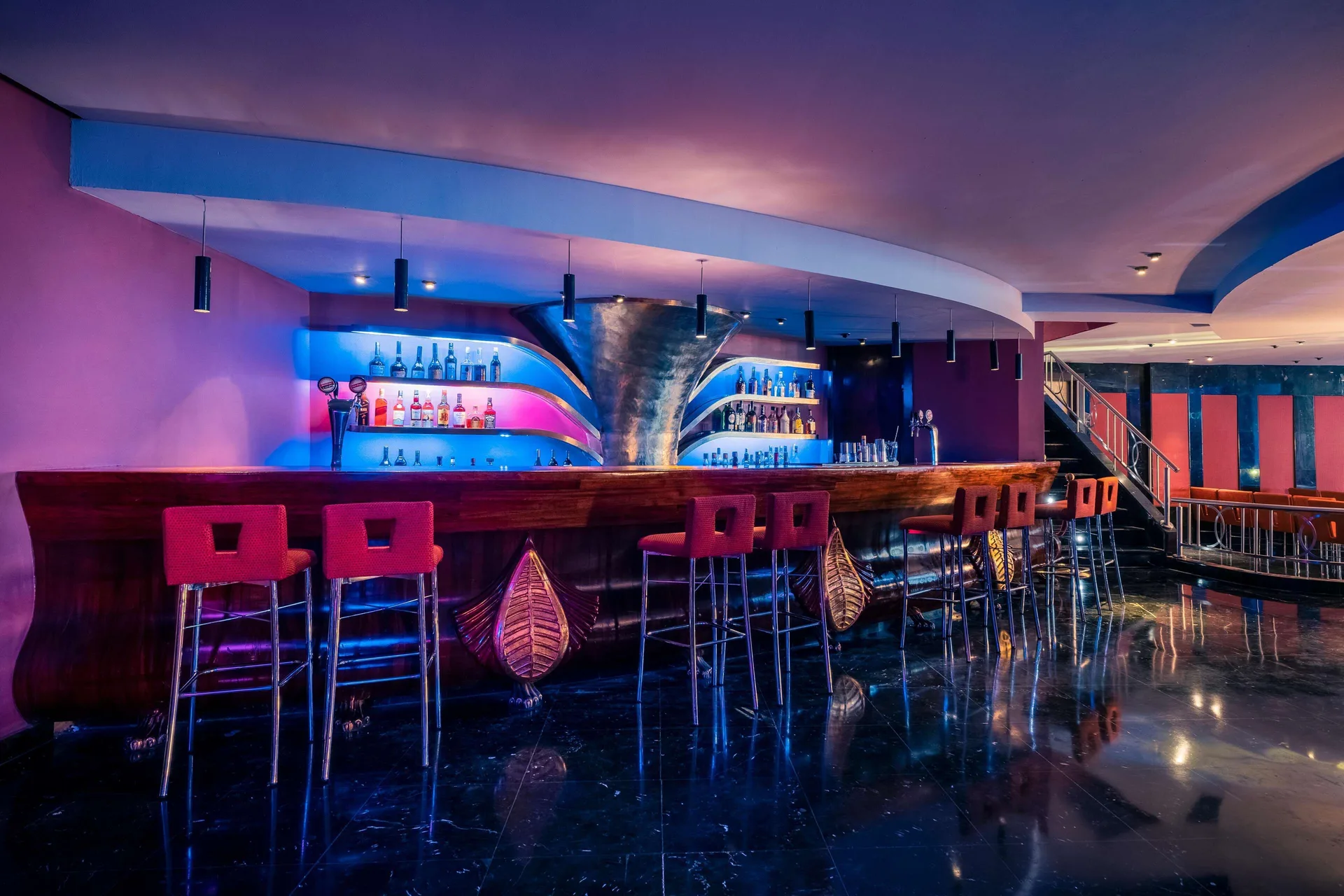 Nightclub bar with purple and blue lighting at JOIA Rose Hall by Iberostar.