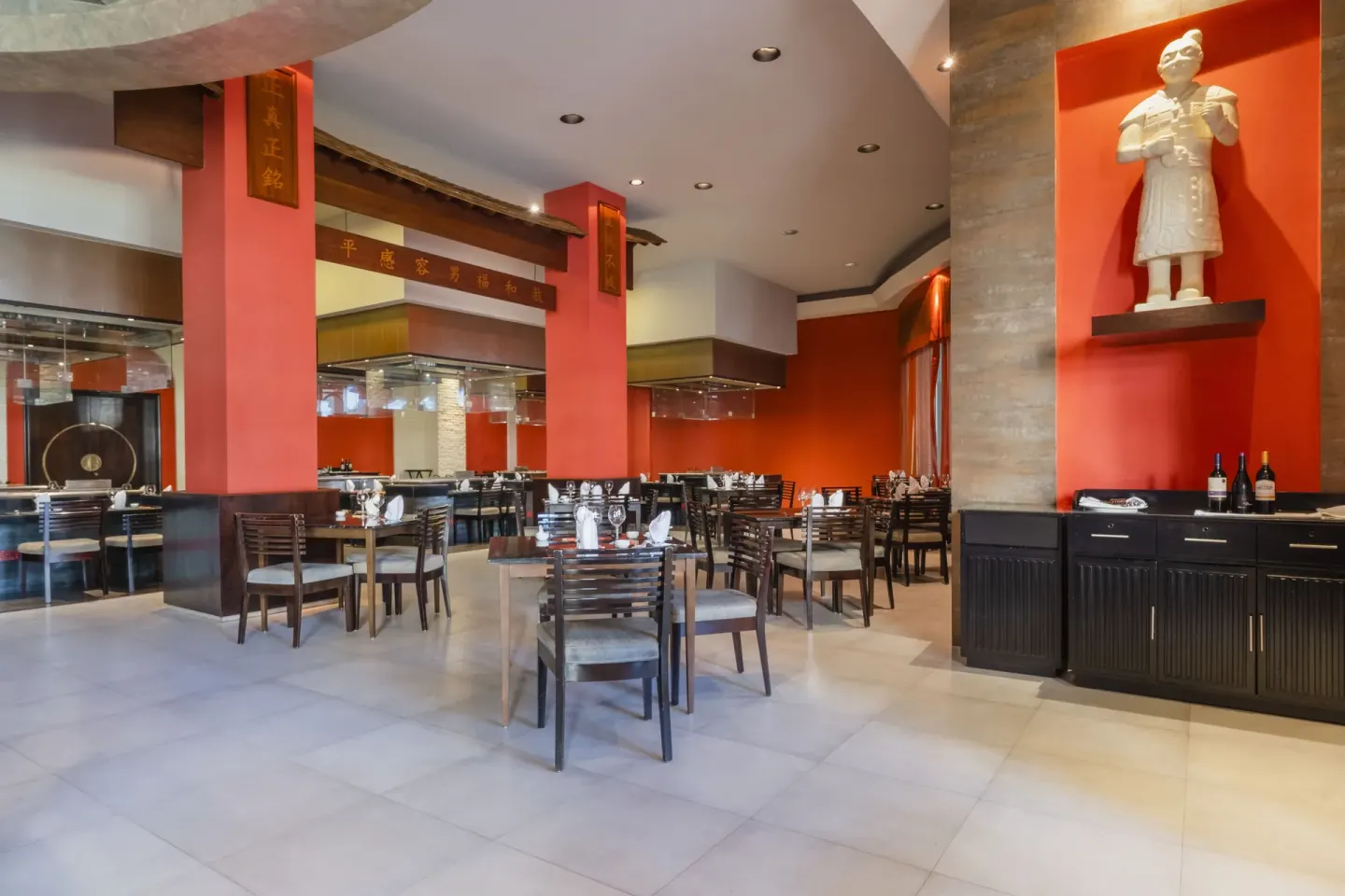 Japanese-style restaurant with red walls and set tables at JOIA Rose Hall by Iberostar.