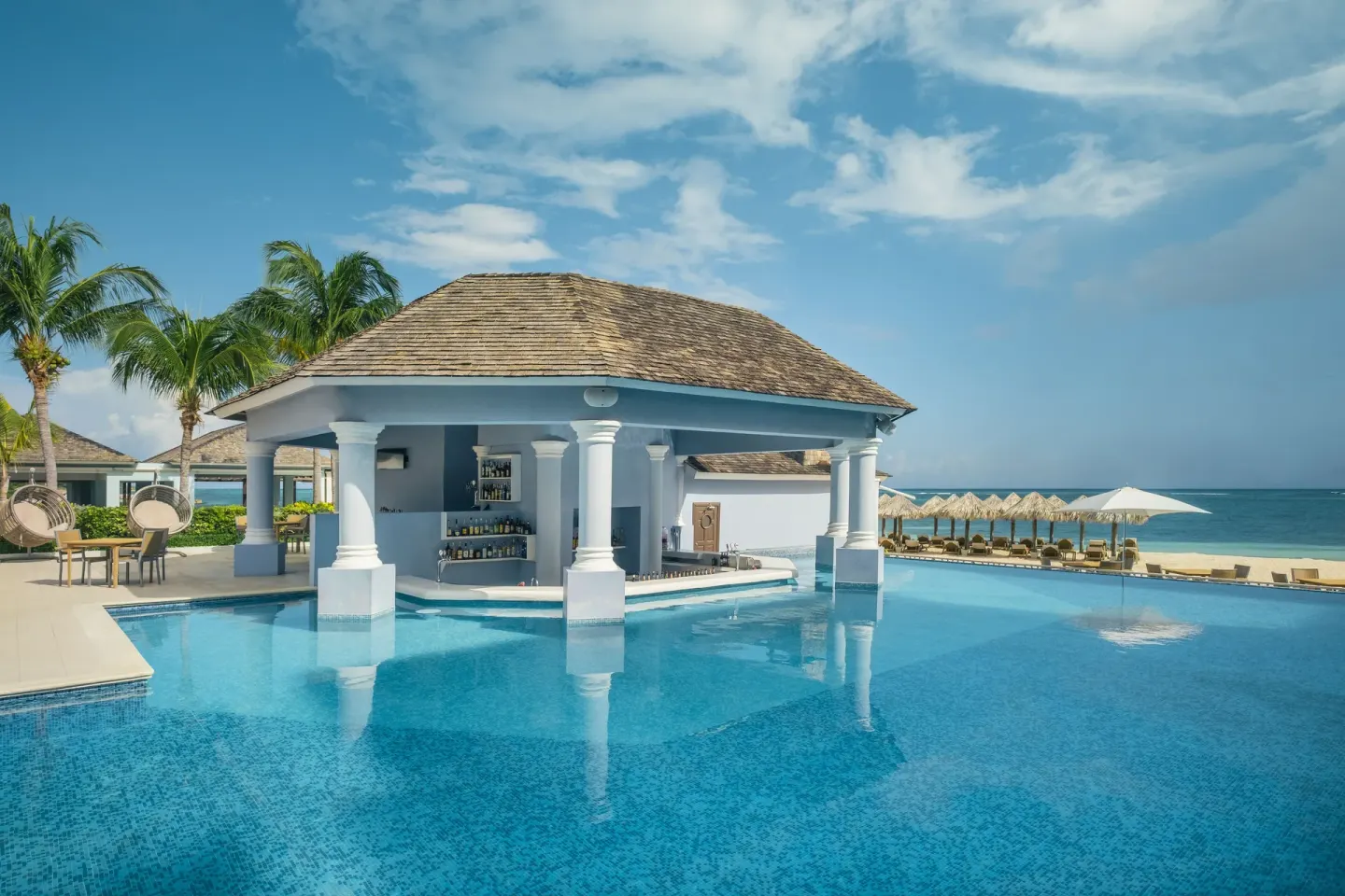 Swim-up bar pavilion in the pool at JOIA Rose Hall by Iberostar.