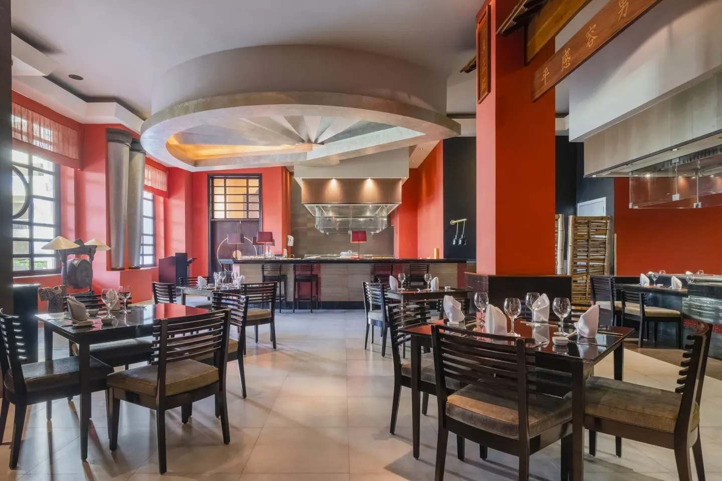 Teppanyaki dining room with black tables and red accents at JOIA Rose Hall by Iberostar.