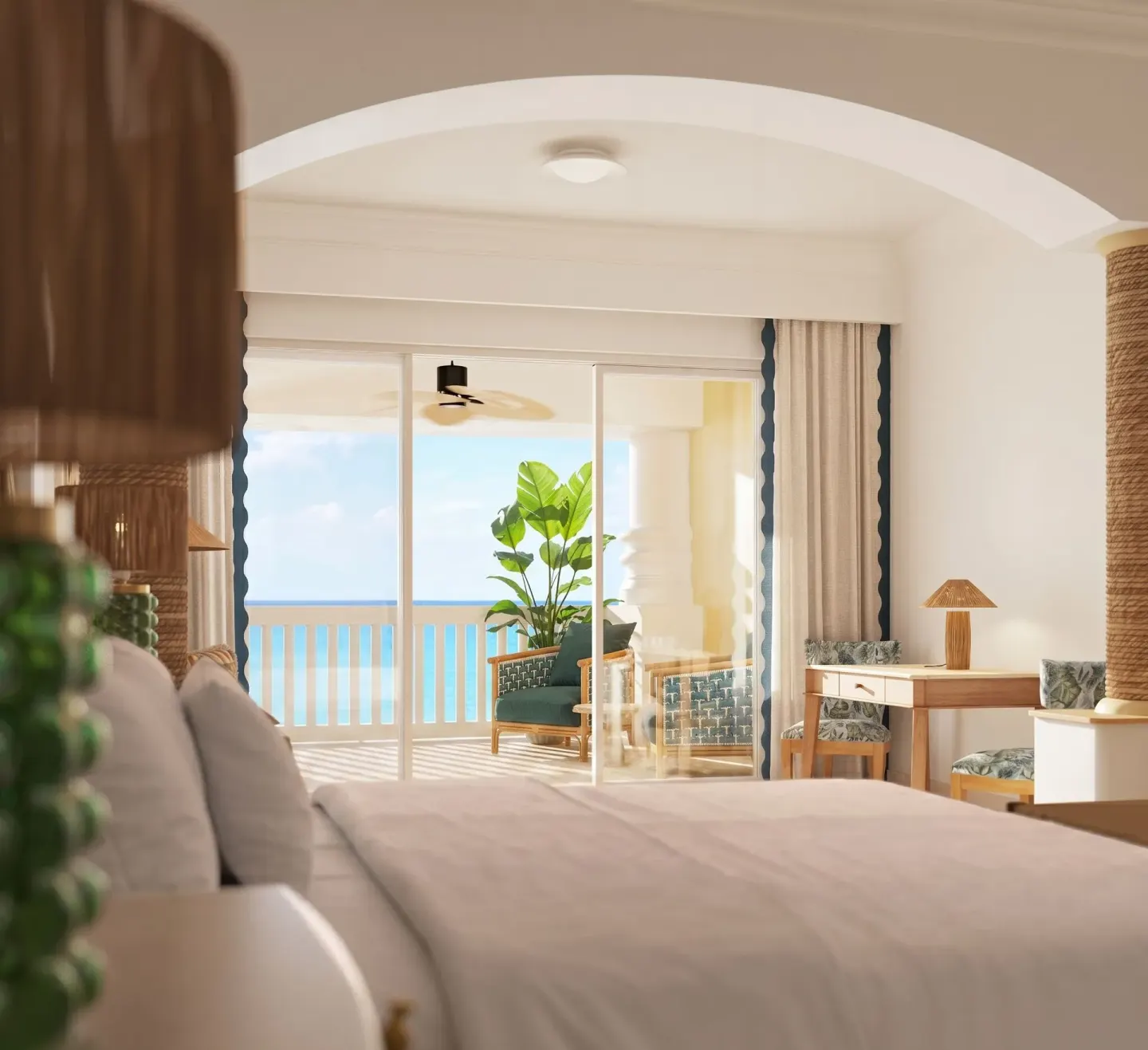 Ocean-front butler suite bedroom with king bed and balcony at JOIA Rose Hall by Iberostar.