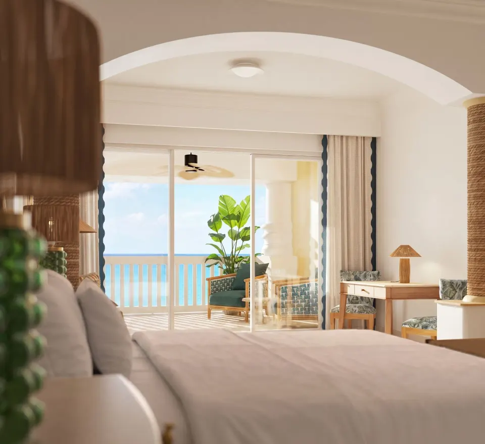 Ocean-front butler suite bedroom with king bed and balcony at JOIA Rose Hall by Iberostar.