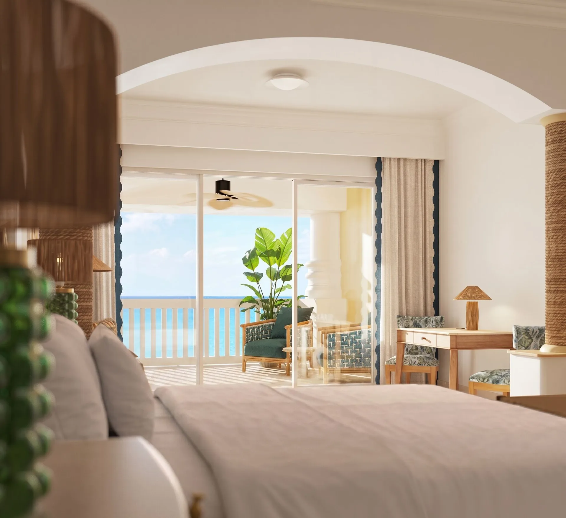 Ocean-front butler suite bedroom with king bed and balcony at JOIA Rose Hall by Iberostar.