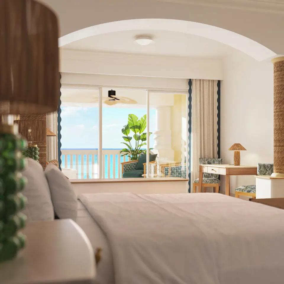 Oceanfront suite king bed and balcony view at JOIA Rose Hall by Iberostar.