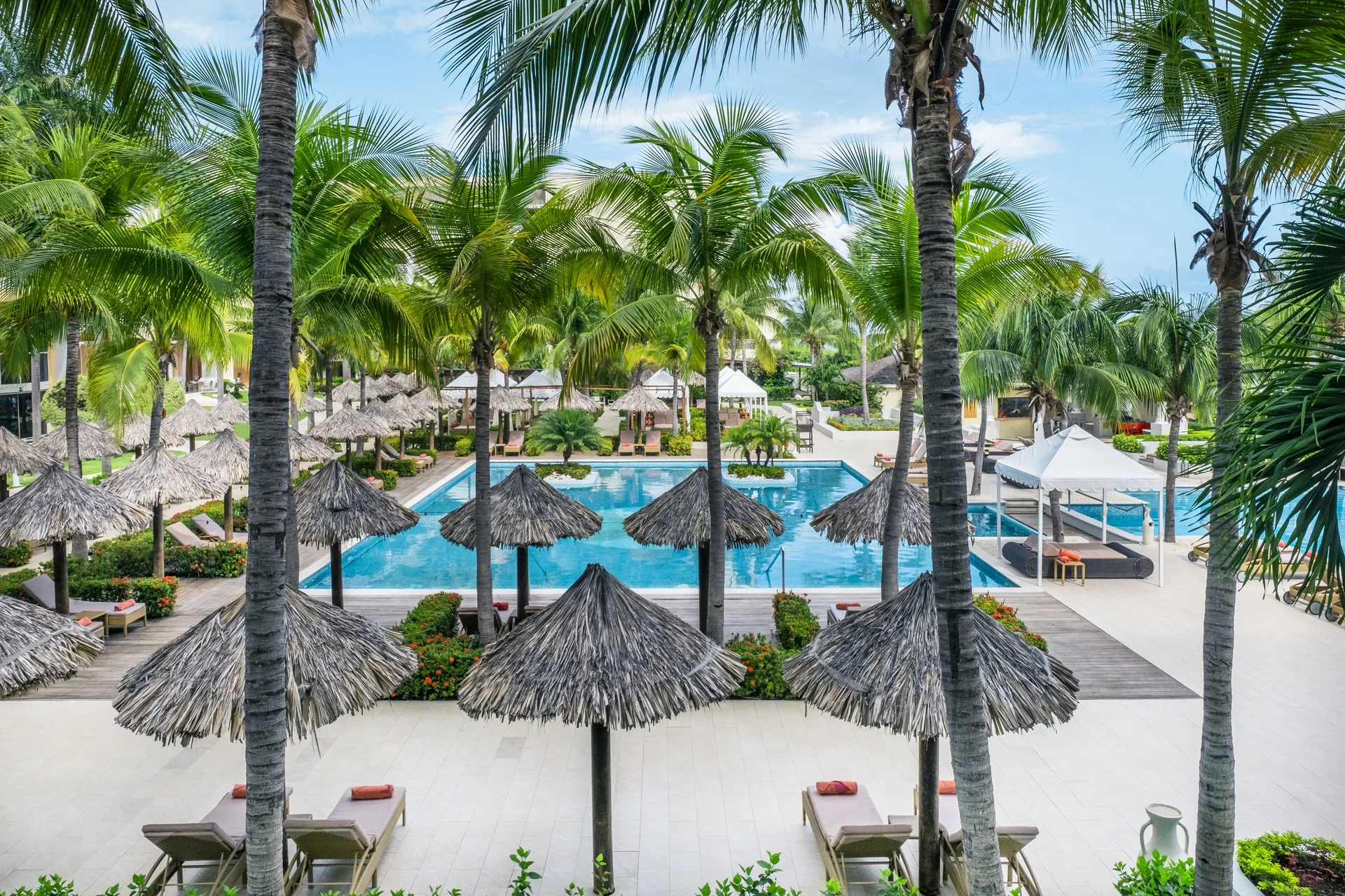 Suite Pool View overlooking palm-lined pools at JOIA Rose Hall by Iberostar.