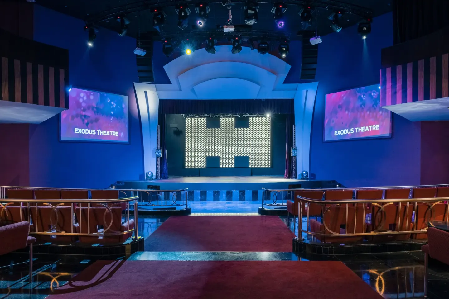 Exodus Theatre stage with screens and seating at JOIA Rose Hall by Iberostar.