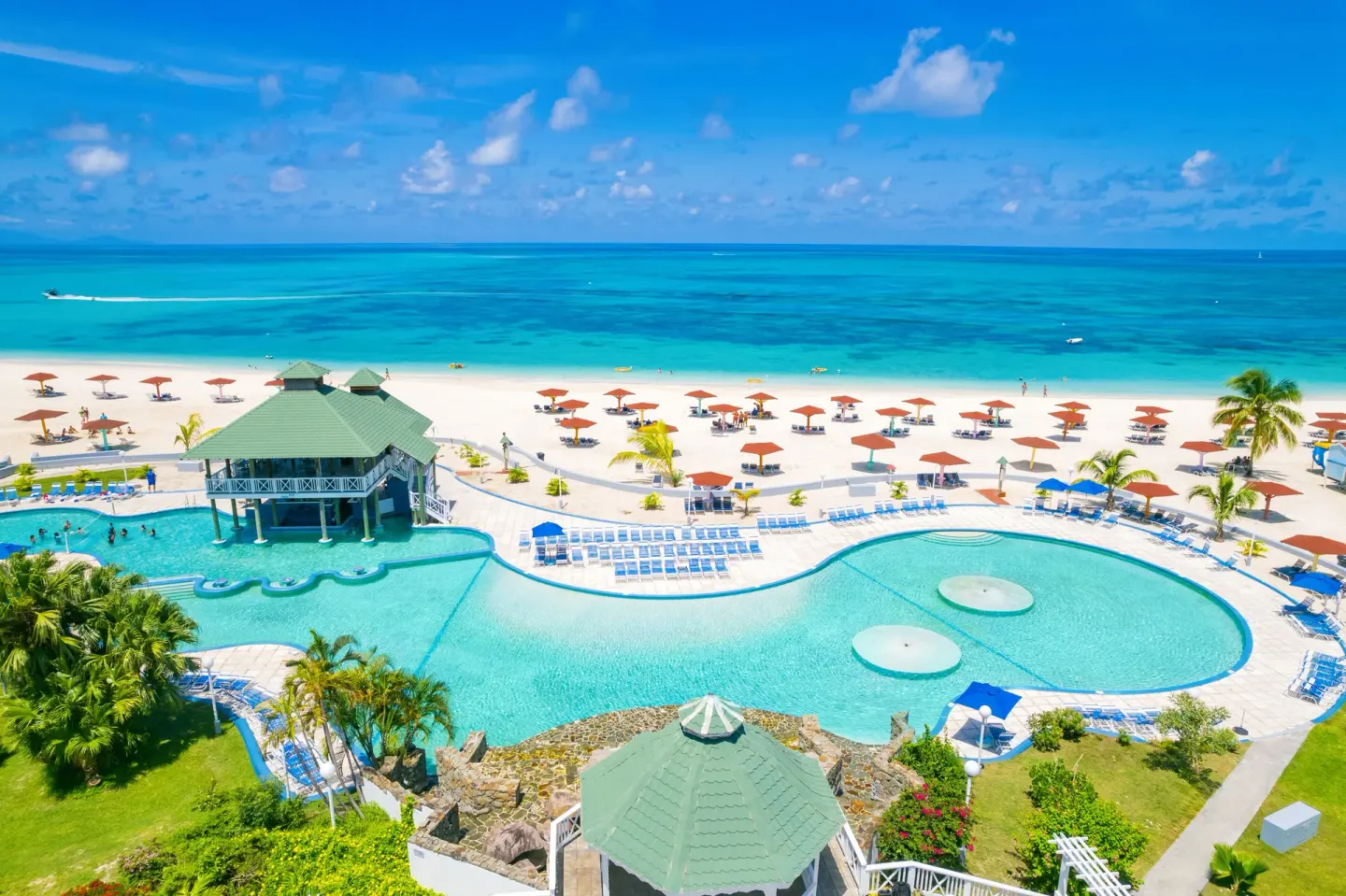 Aerial view of the beachfront pools and white sand at Jolly Beach Antigua.