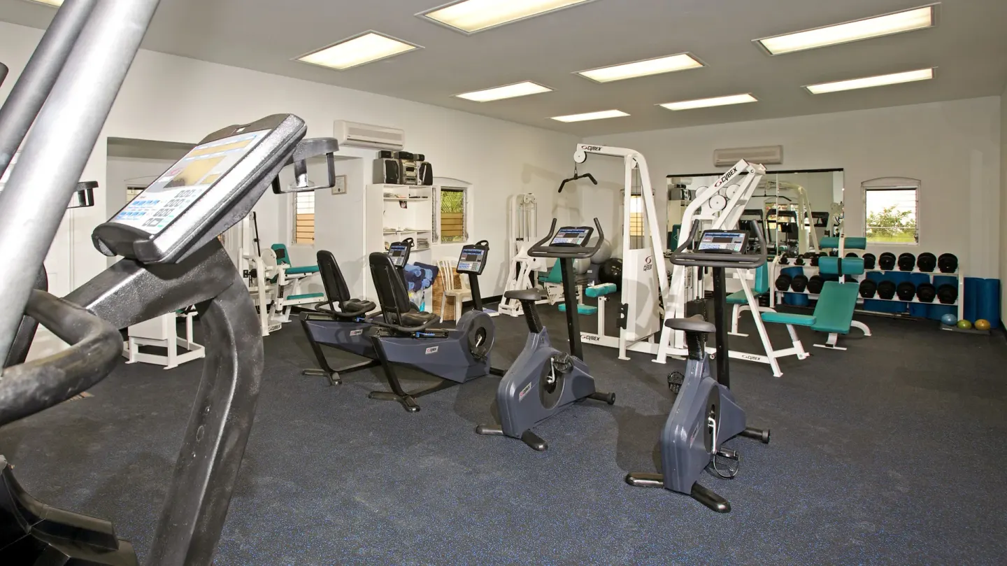 Gym with cardio machines, weights, and benches at Jolly Beach Antigua.