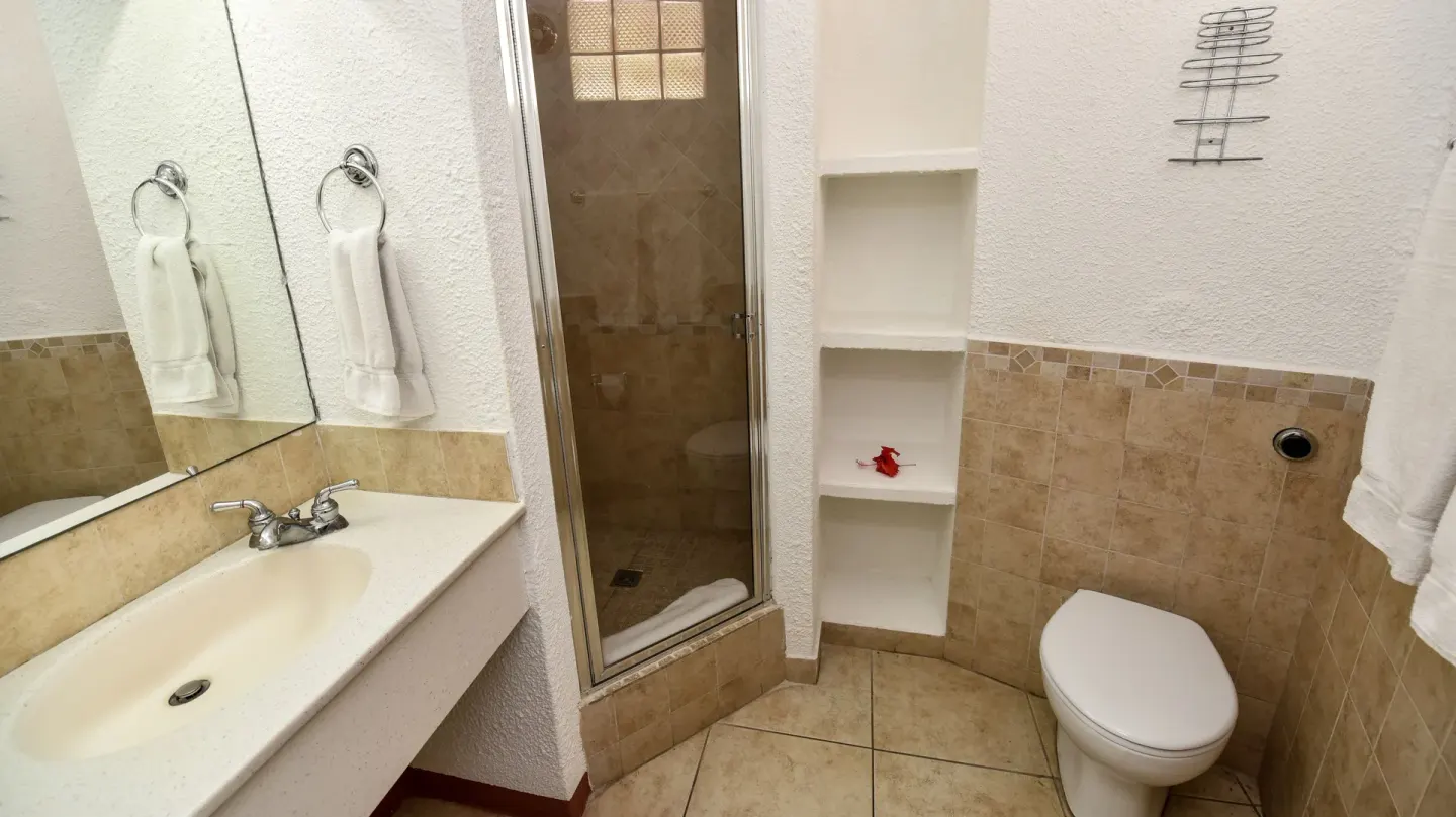 Super Saver Room bathroom with shower, sink, and toilet at Jolly Beach Antigua.