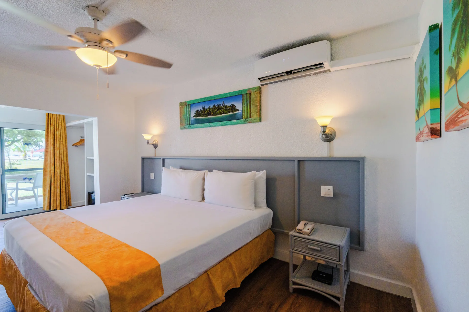 Superior Room king bed with bedside table and wall art at Jolly Beach Antigua.