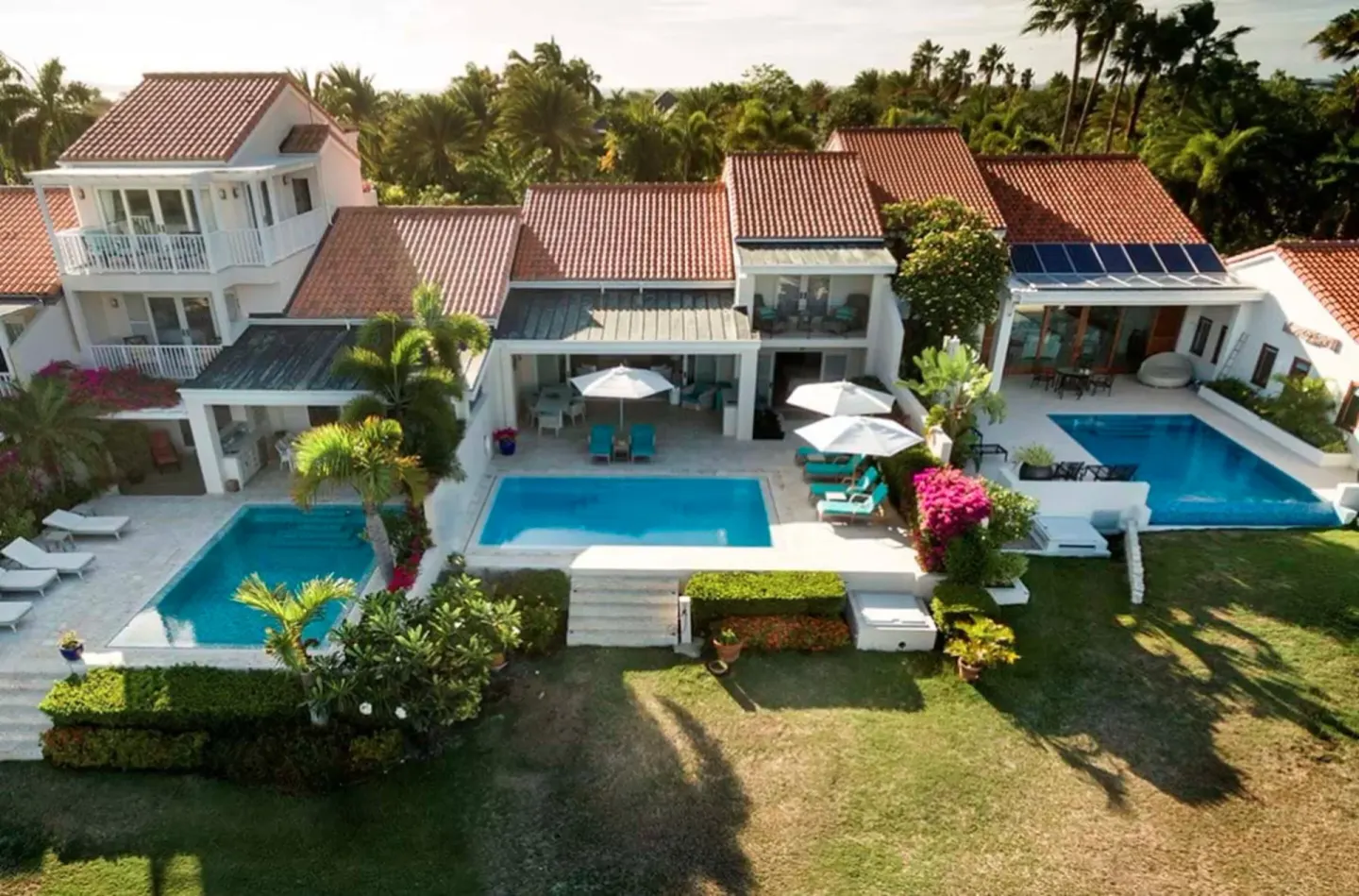 Aerial view of villa pools, terraces and red-tile roofs at Jumby Bay Island.