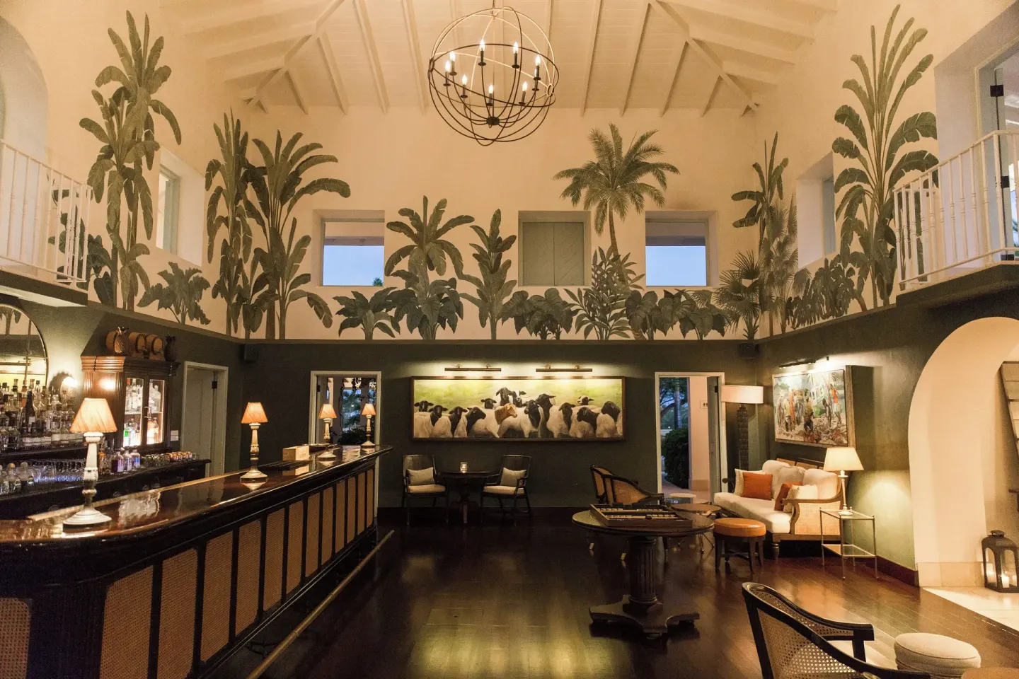 Lounge bar with tropical murals and seating at Jumby Bay Island.