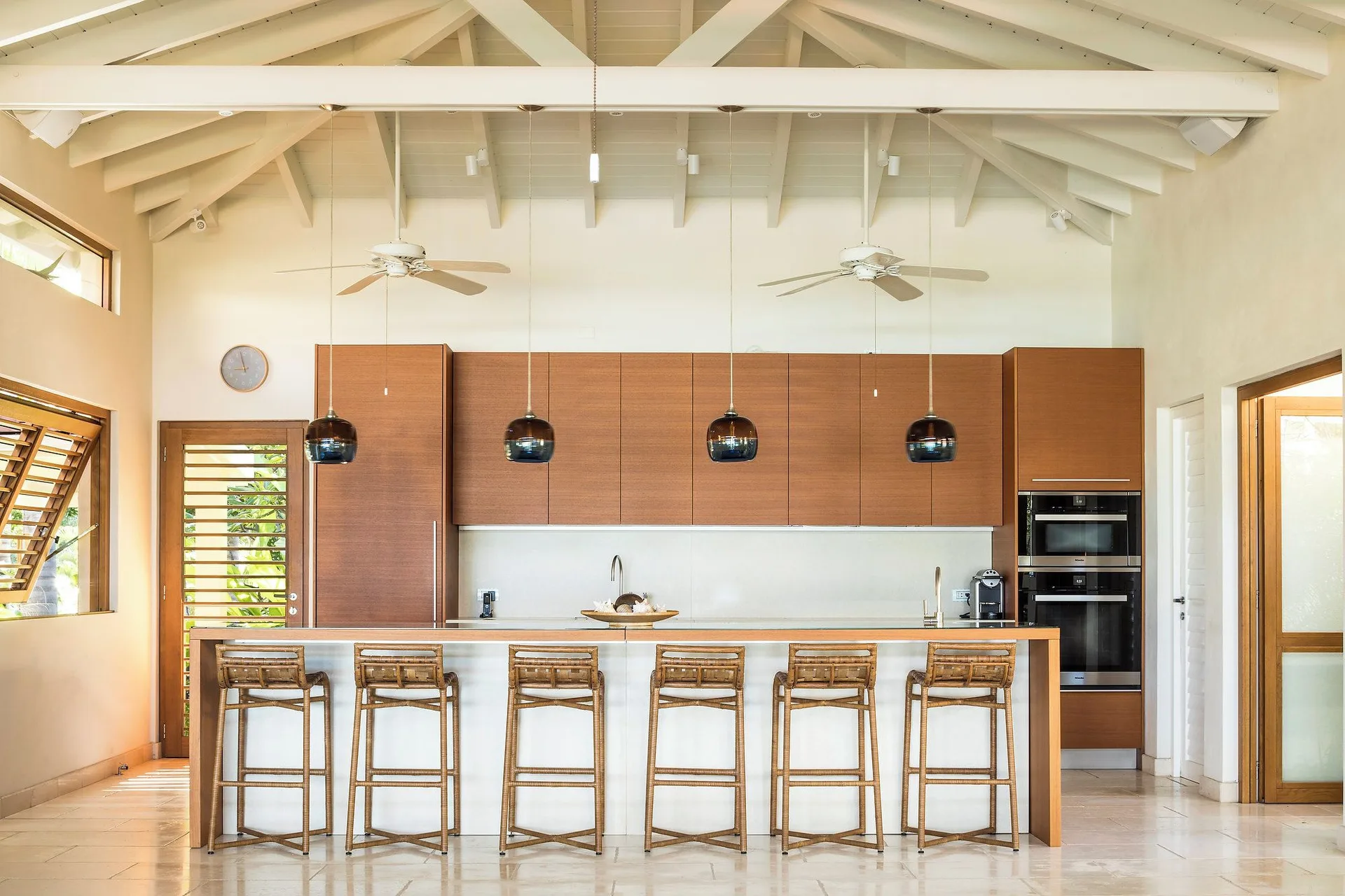 Allamanda kitchen with island seating and wood cabinetry at Jumby Bay Island.