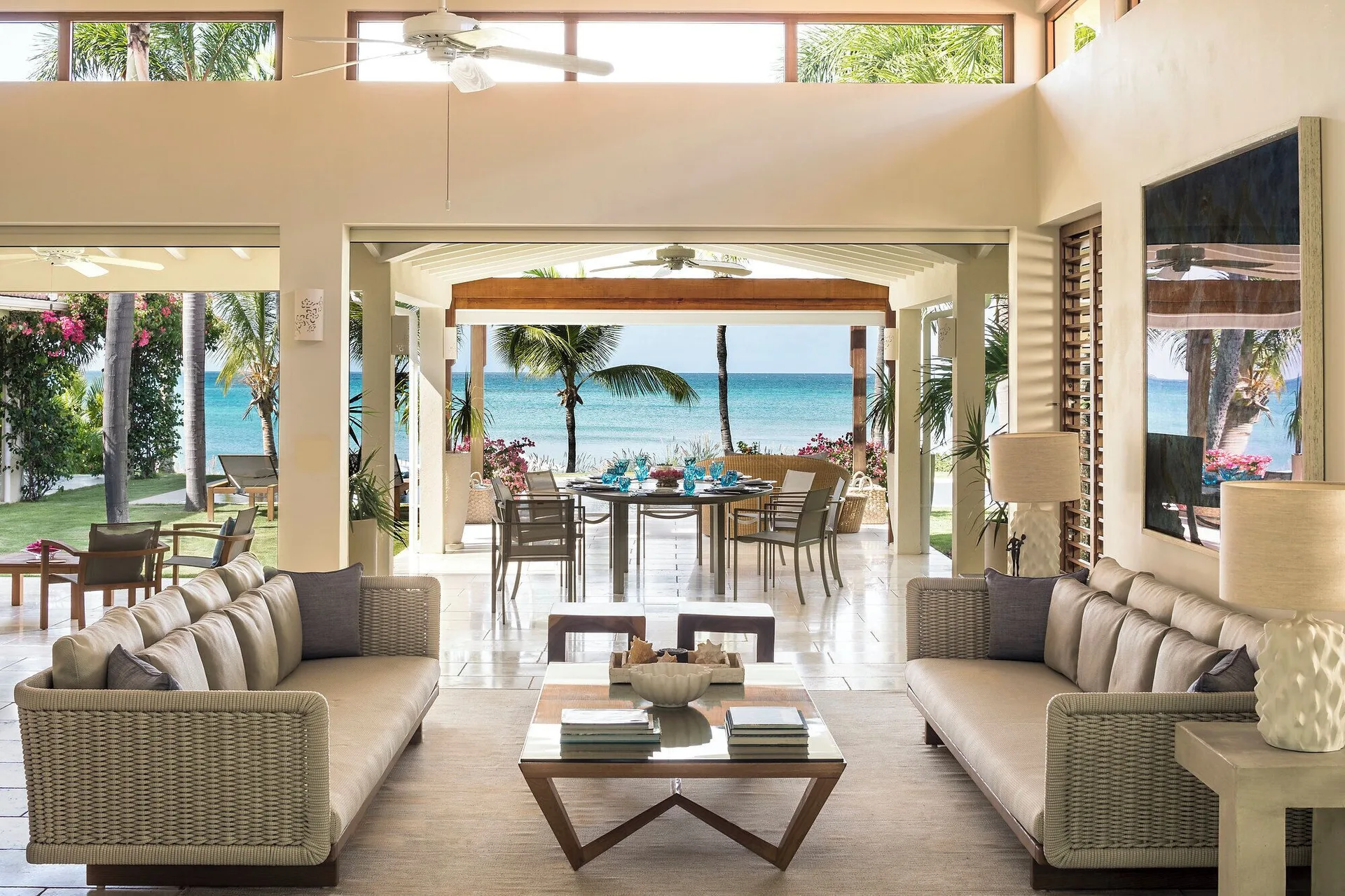 Allamanda living room opening to a dining terrace and ocean view at Jumby Bay Island.