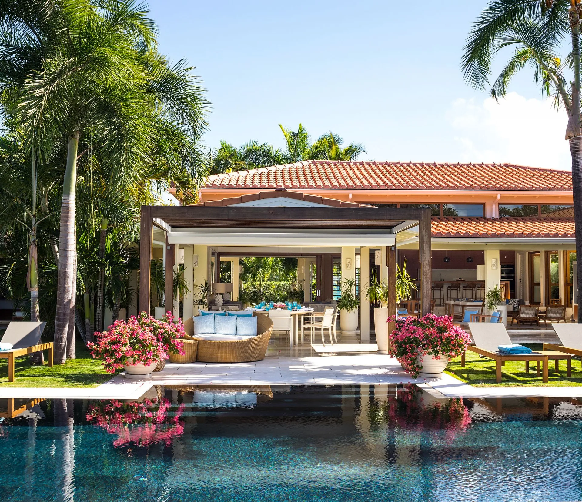 Allamanda exterior with pool, terrace seating and palm trees at Jumby Bay Island.