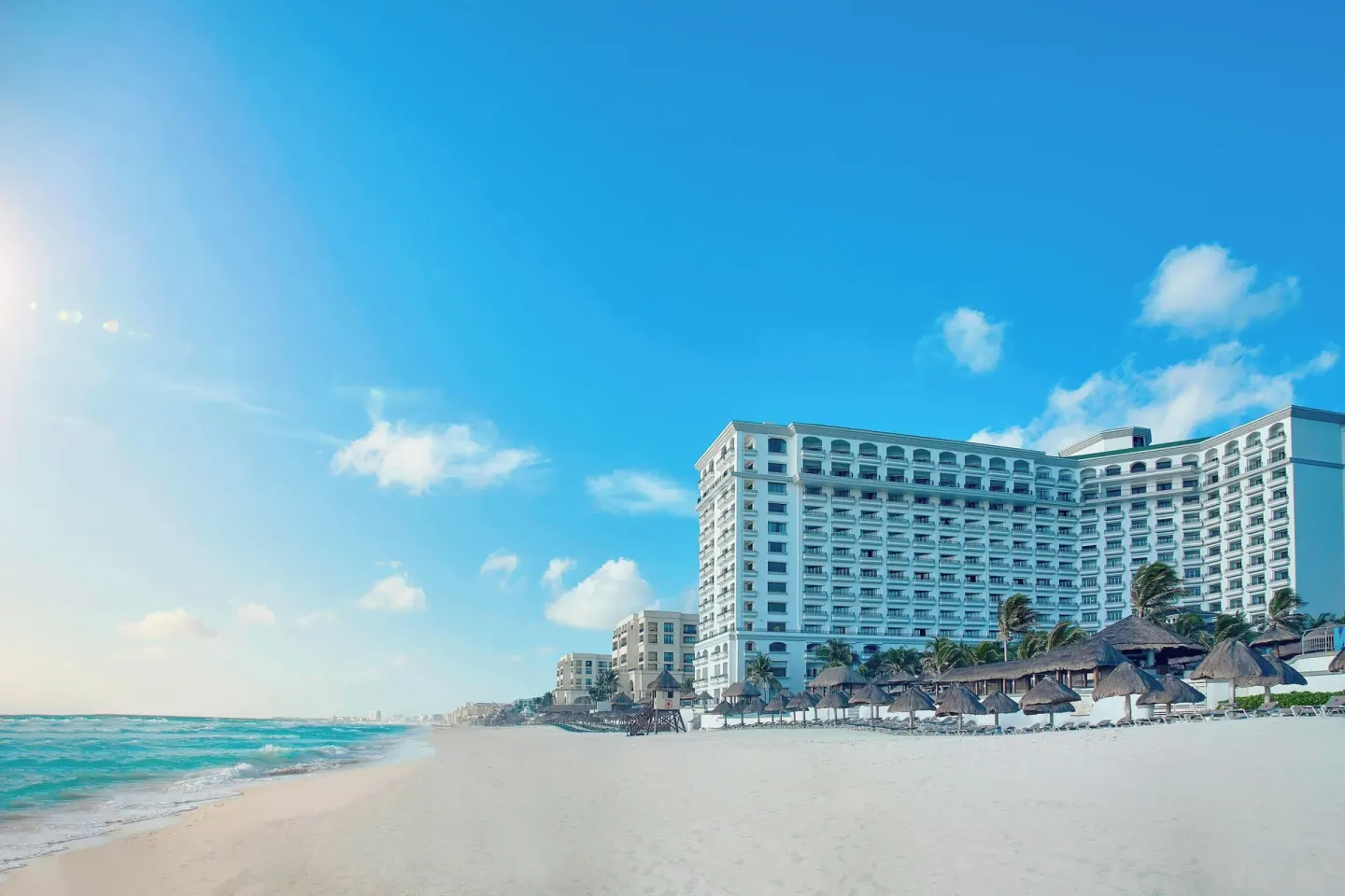 Beachfront hotel tower and palapas at JW Marriott Cancun Resort & Spa.