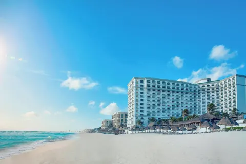 Beachfront hotel tower and palapas at JW Marriott Cancun Resort & Spa.