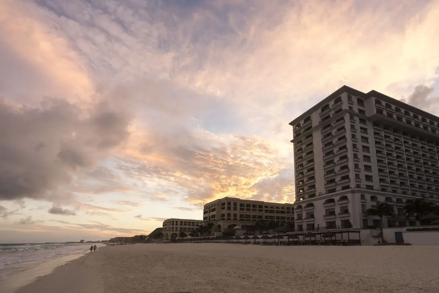 Beachfront hotel towers at sunset at JW Marriott Cancun Resort & Spa.