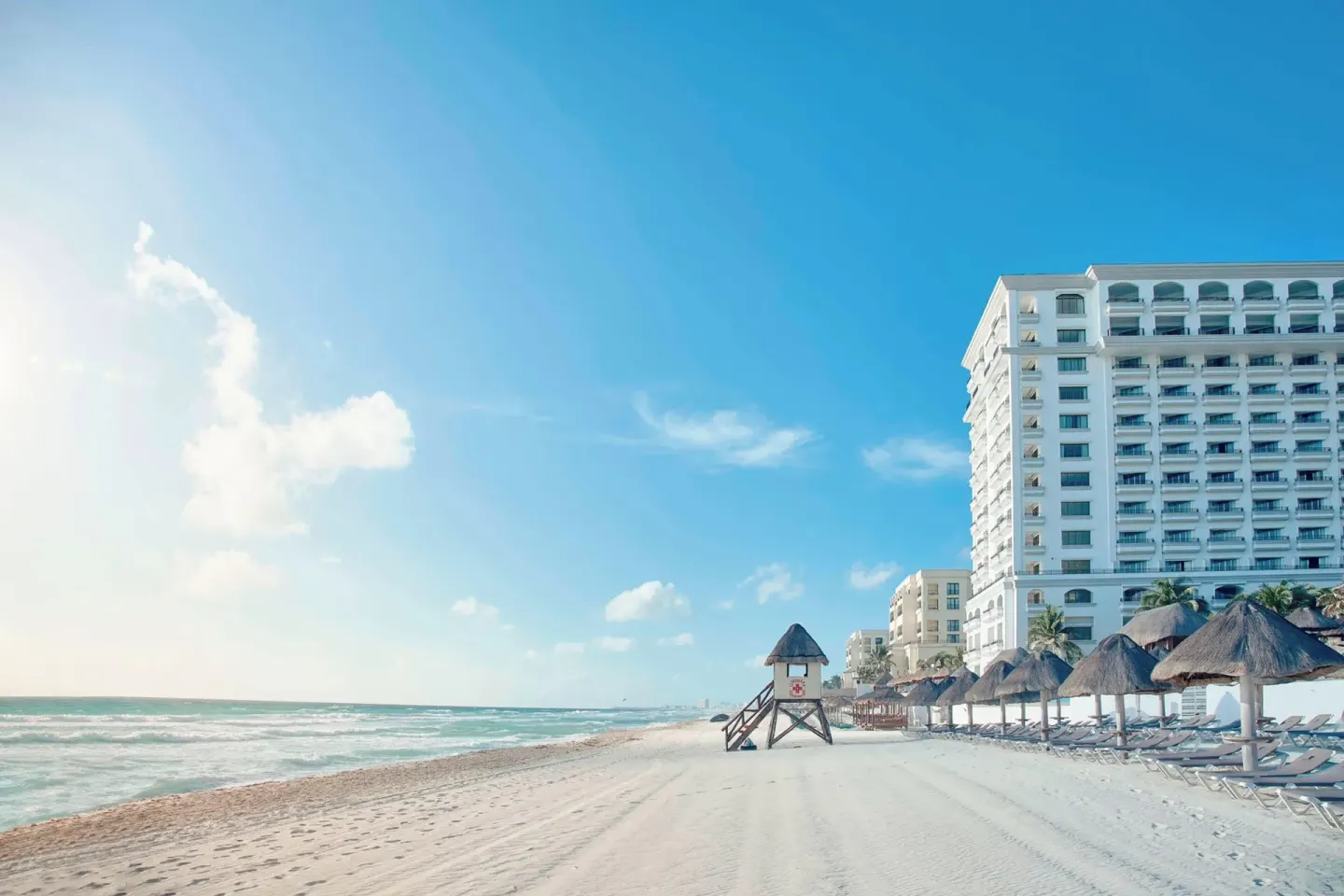 Beachfront tower, lifeguard stand, and palapas at JW Marriott Cancun Resort & Spa.