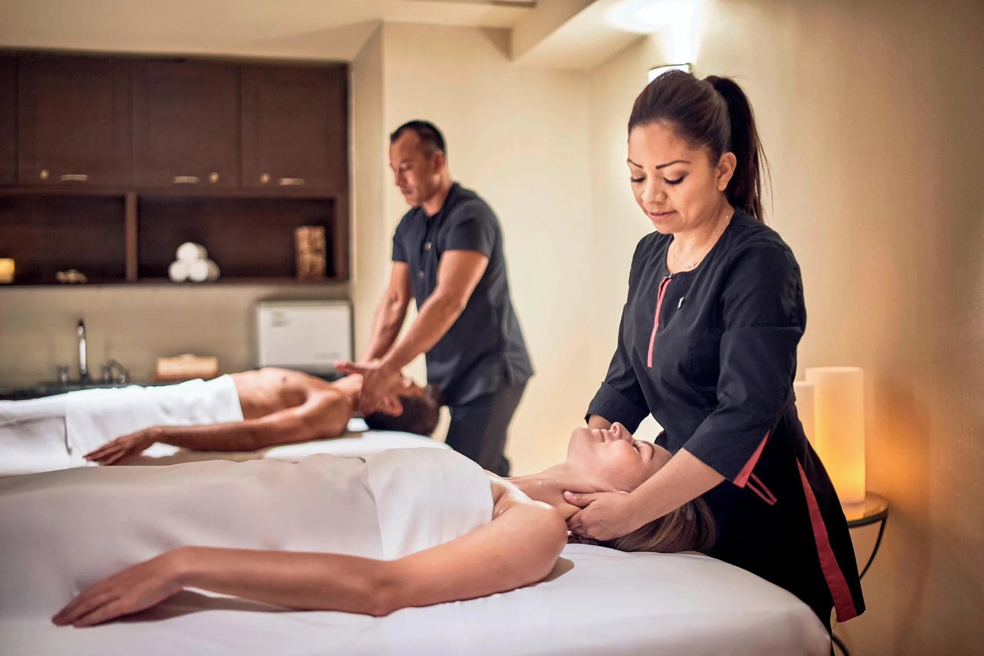 Spa treatment room with two therapists giving massages at JW Marriott Cancun Resort & Spa.