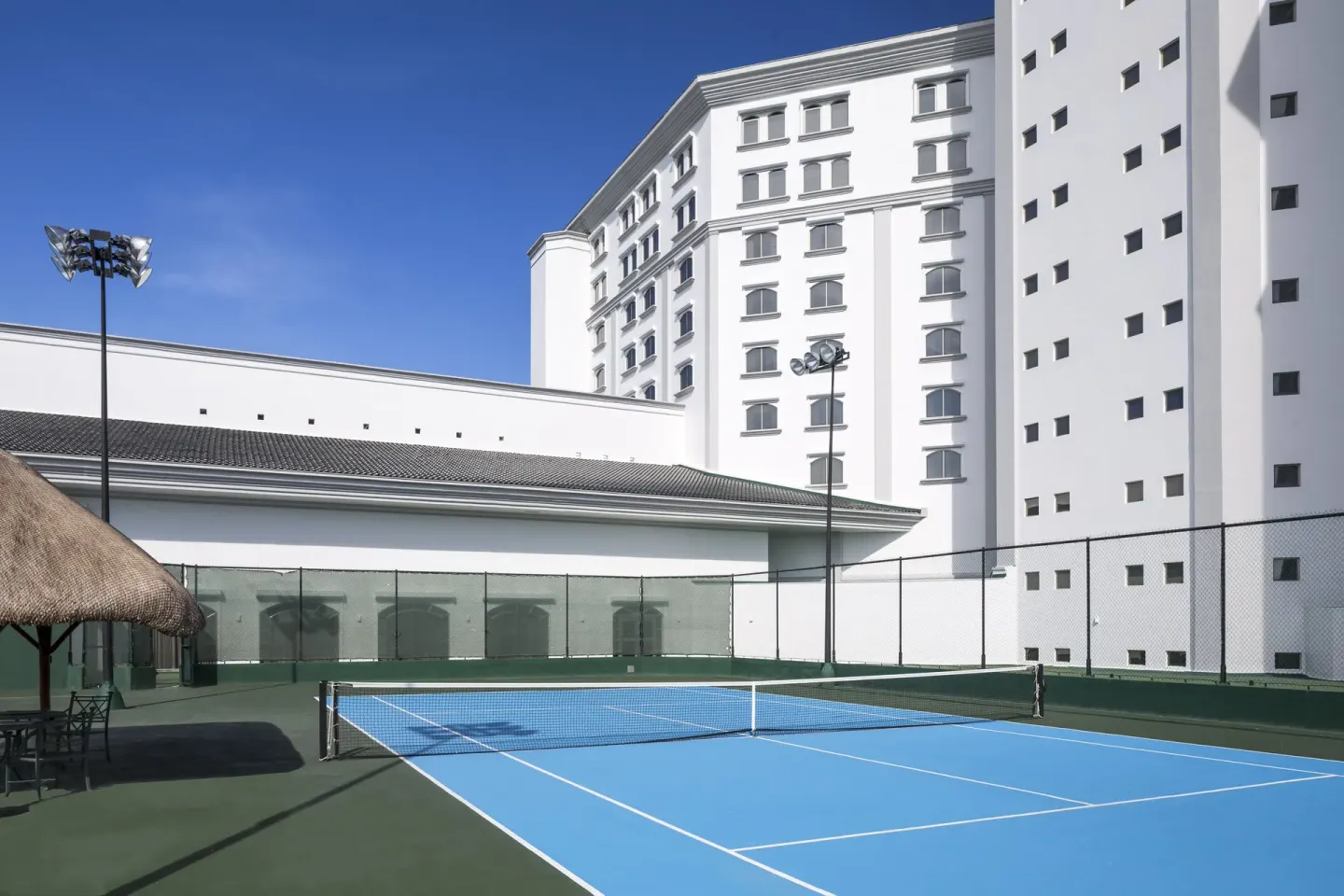 Outdoor tennis court beside the hotel tower at JW Marriott Cancun Resort & Spa.