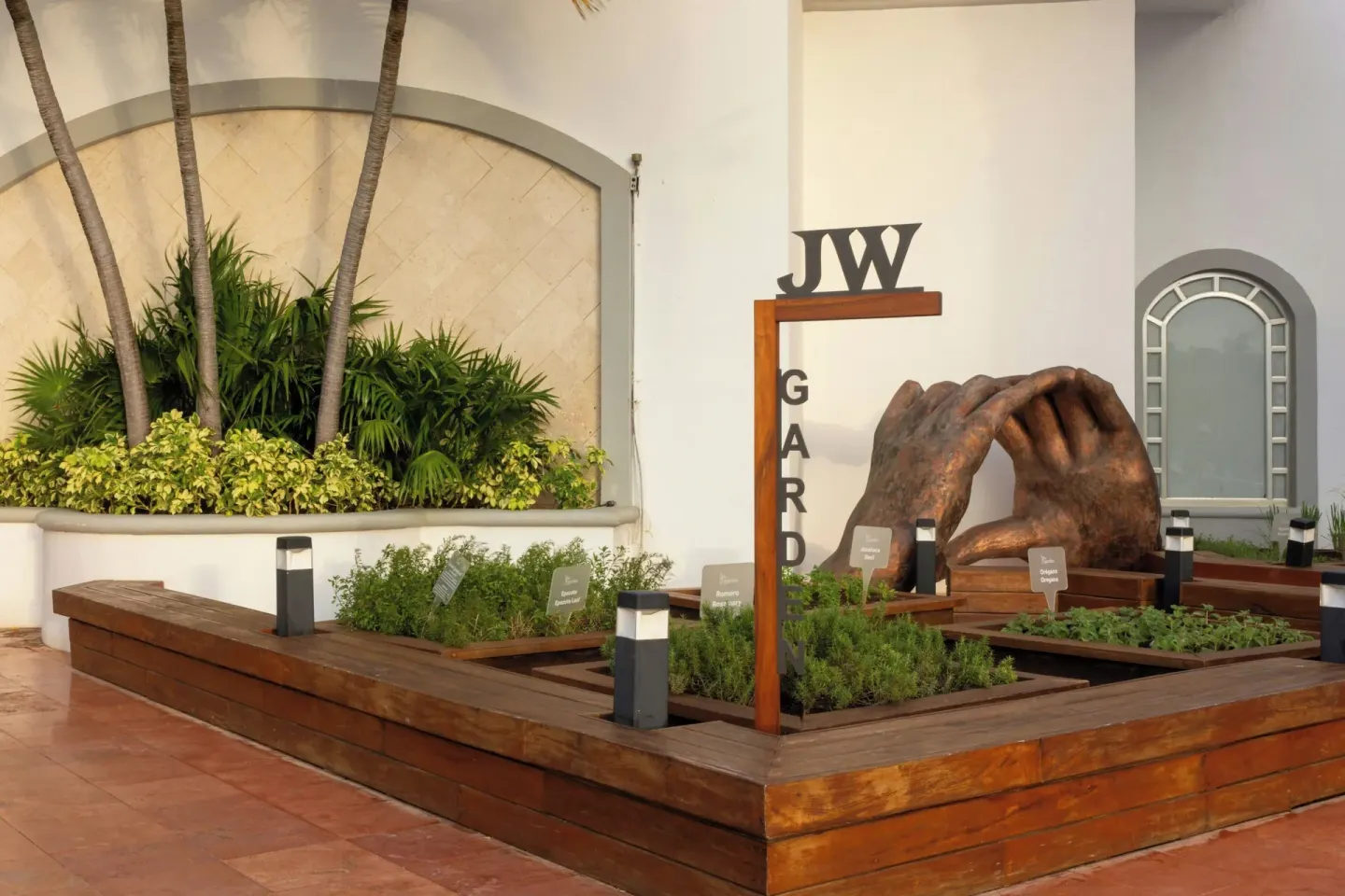 Herb garden with a hand sculpture at JW Marriott Cancun Resort & Spa.