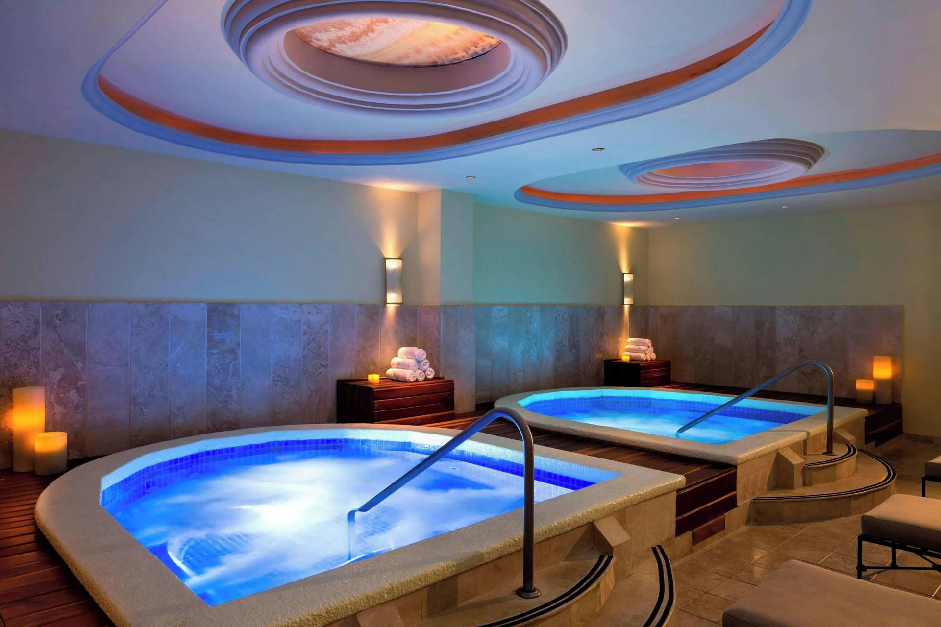 Spa whirlpool tubs glowing blue with towels and candles at JW Marriott Cancun Resort & Spa.