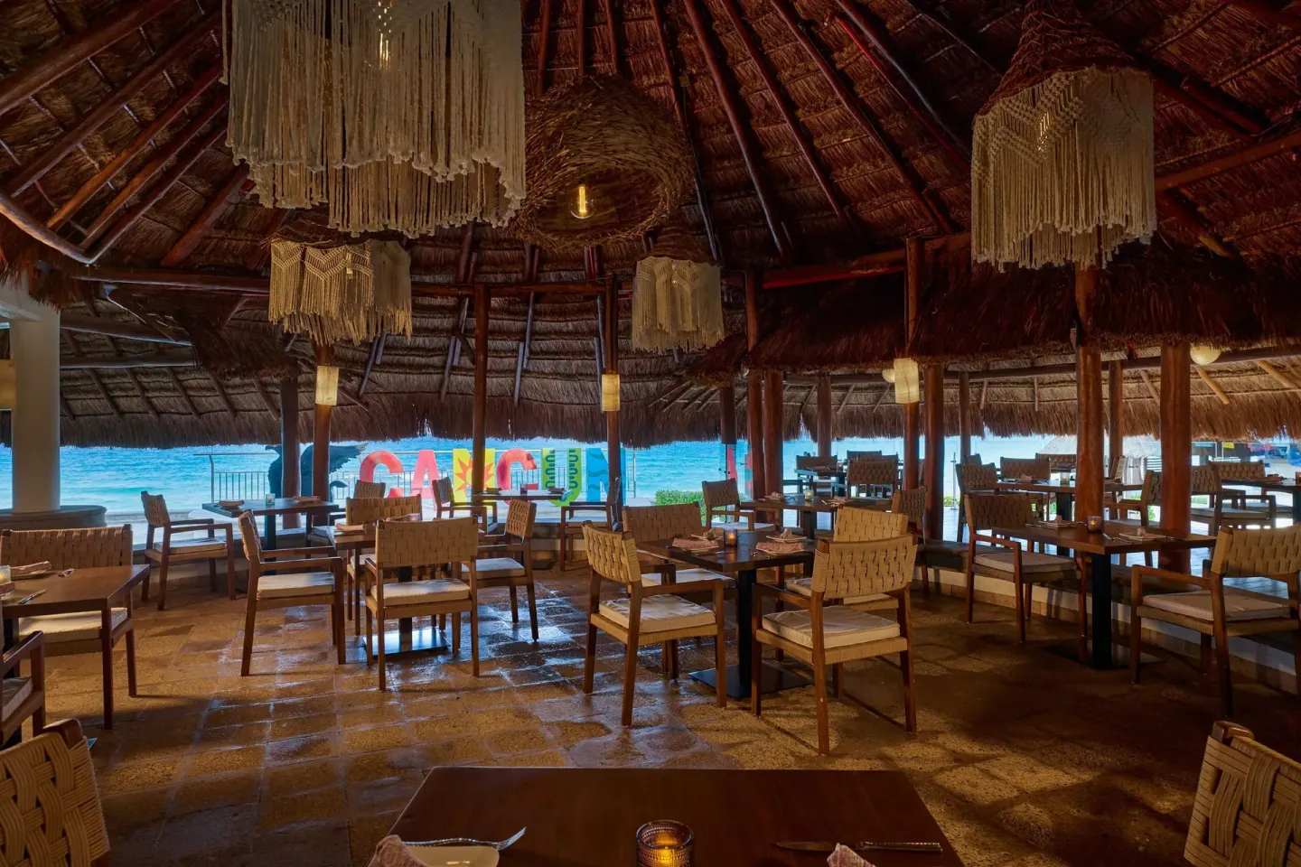 BeachWalk dining room with thatched roof and ocean view at JW Marriott Cancun Resort & Spa.