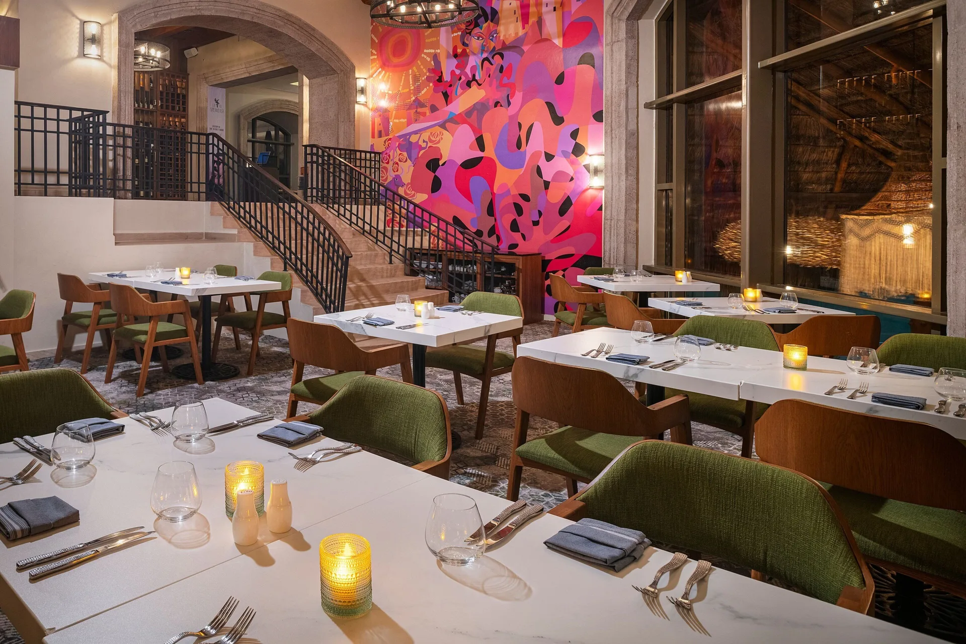 Restaurant tables beside a colorful mural at JW Marriott Cancun Resort & Spa.