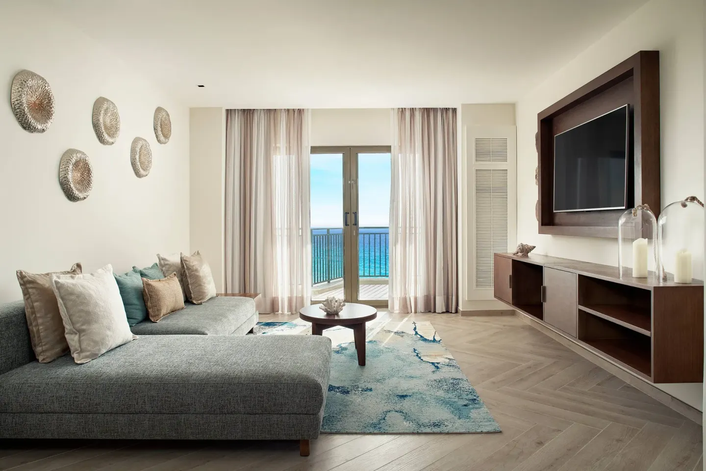 Presidential Suite sitting area with sectional sofa and balcony doors at JW Marriott Cancun Resort & Spa.