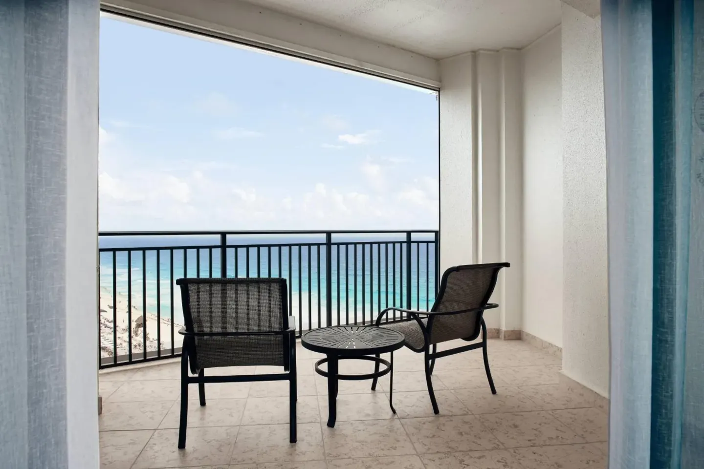 Deluxe Room Ocean View balcony with chairs and ocean at JW Marriott Cancun Resort & Spa.