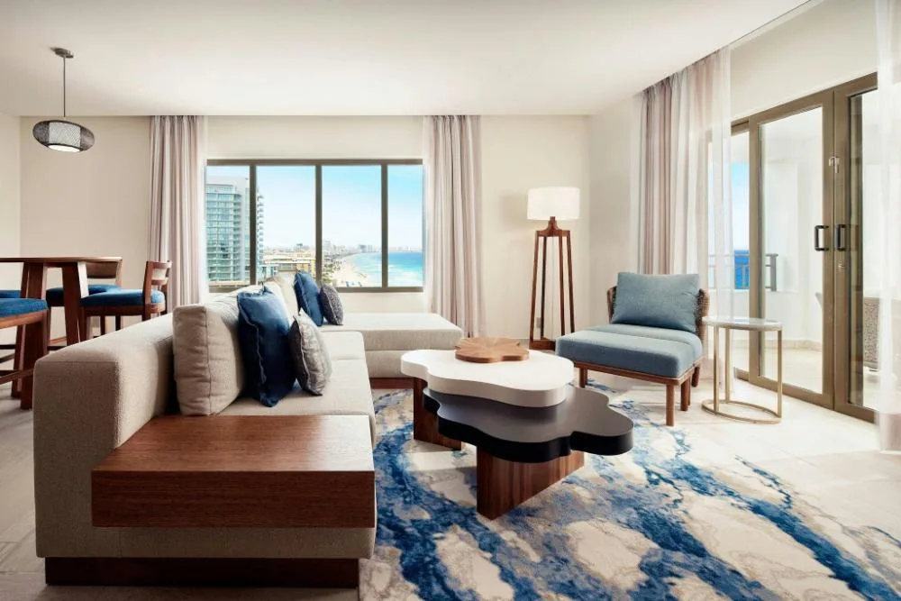 Grand Ocean Front Suite living area with sofa bed at JW Marriott Cancun Resort and Spa featuring modern decor and oceanfront views.