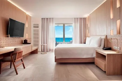 Junior suite king bedroom with balcony view at JW Marriott Cancun Resort & Spa.
