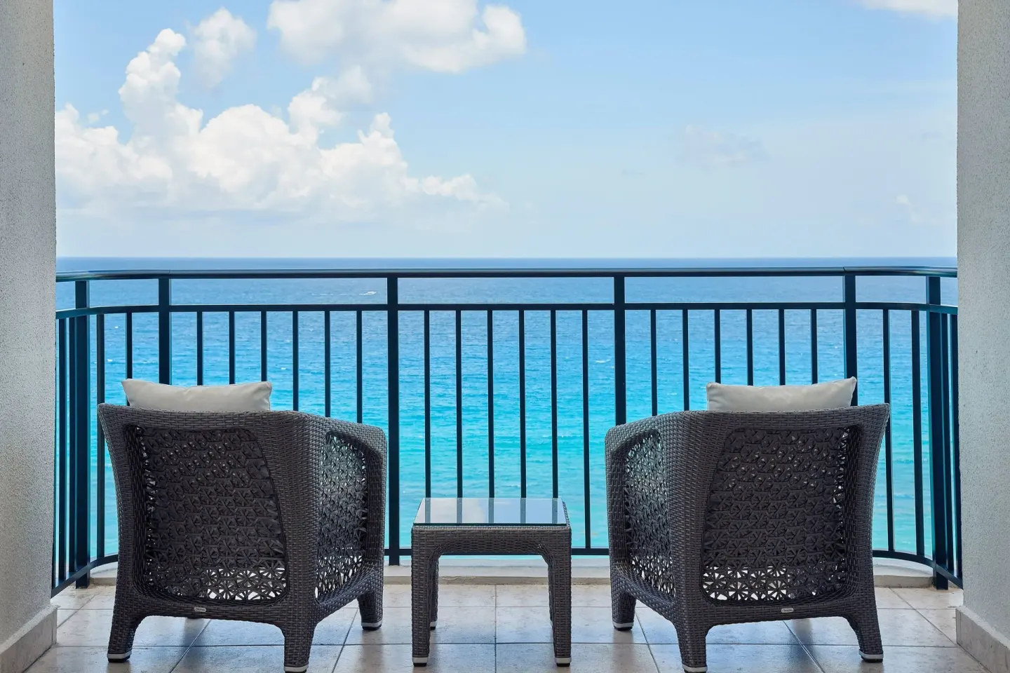 Junior Suite balcony with two chairs overlooking the ocean at JW Marriott Cancun Resort & Spa.