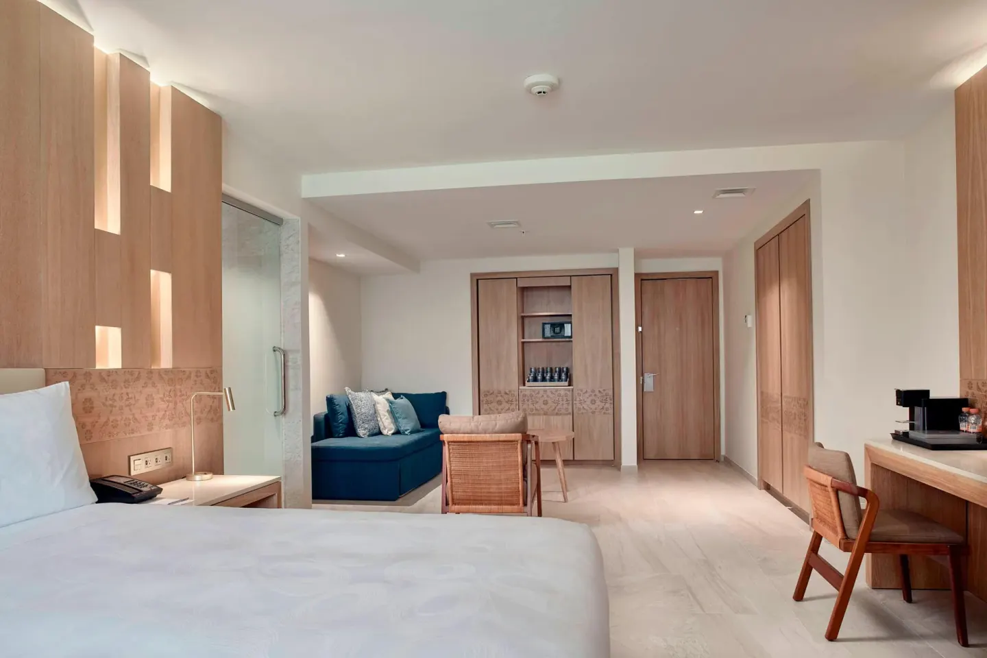 Junior Suite king bed with sofa seating and wet bar at JW Marriott Cancun Resort & Spa.