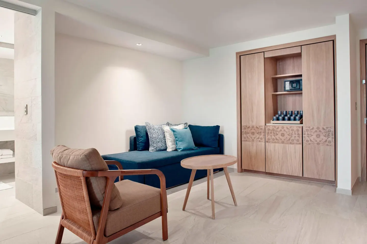 Junior Suite sitting area with chair, sofa, and table at JW Marriott Cancun Resort & Spa.