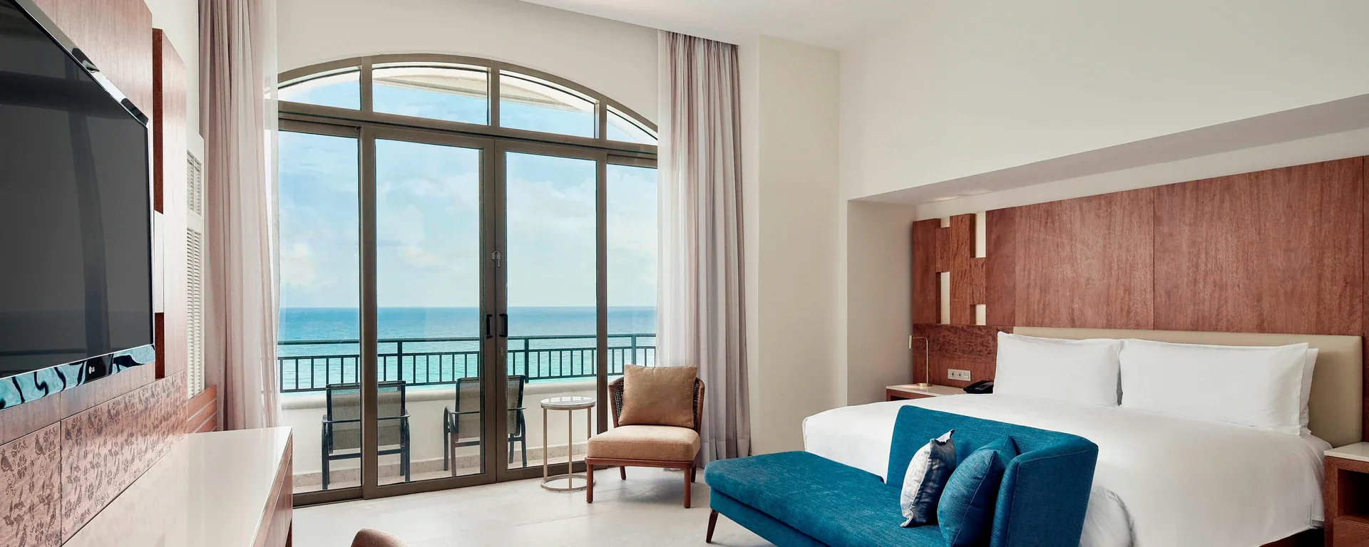 Ocean Room king bed and balcony view at JW Marriott Cancun Resort & Spa.