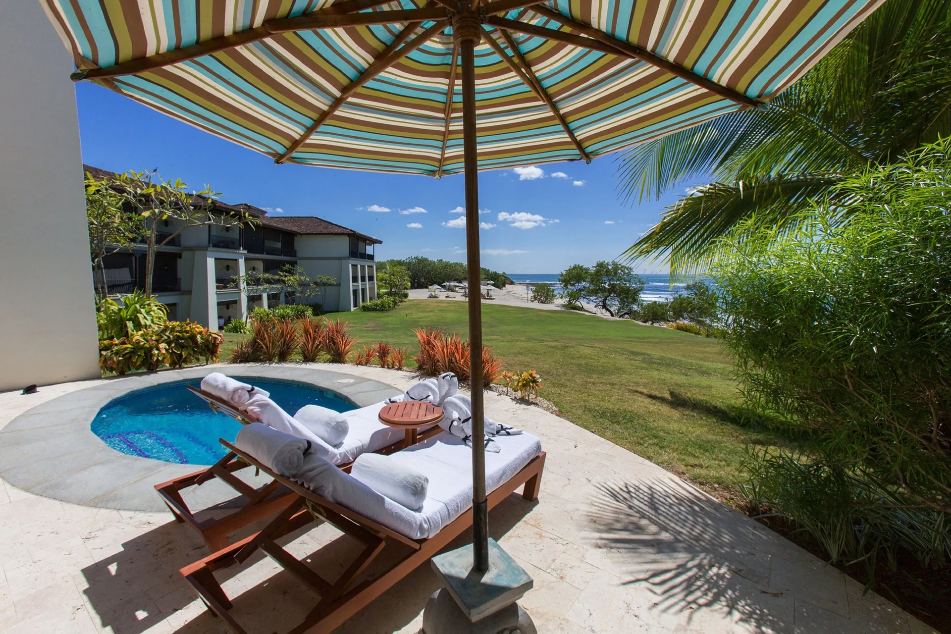 Beachfront plunge pool terrace at JW Marriott Guanacaste Resort and Spa with umbrella loungers and ocean view.