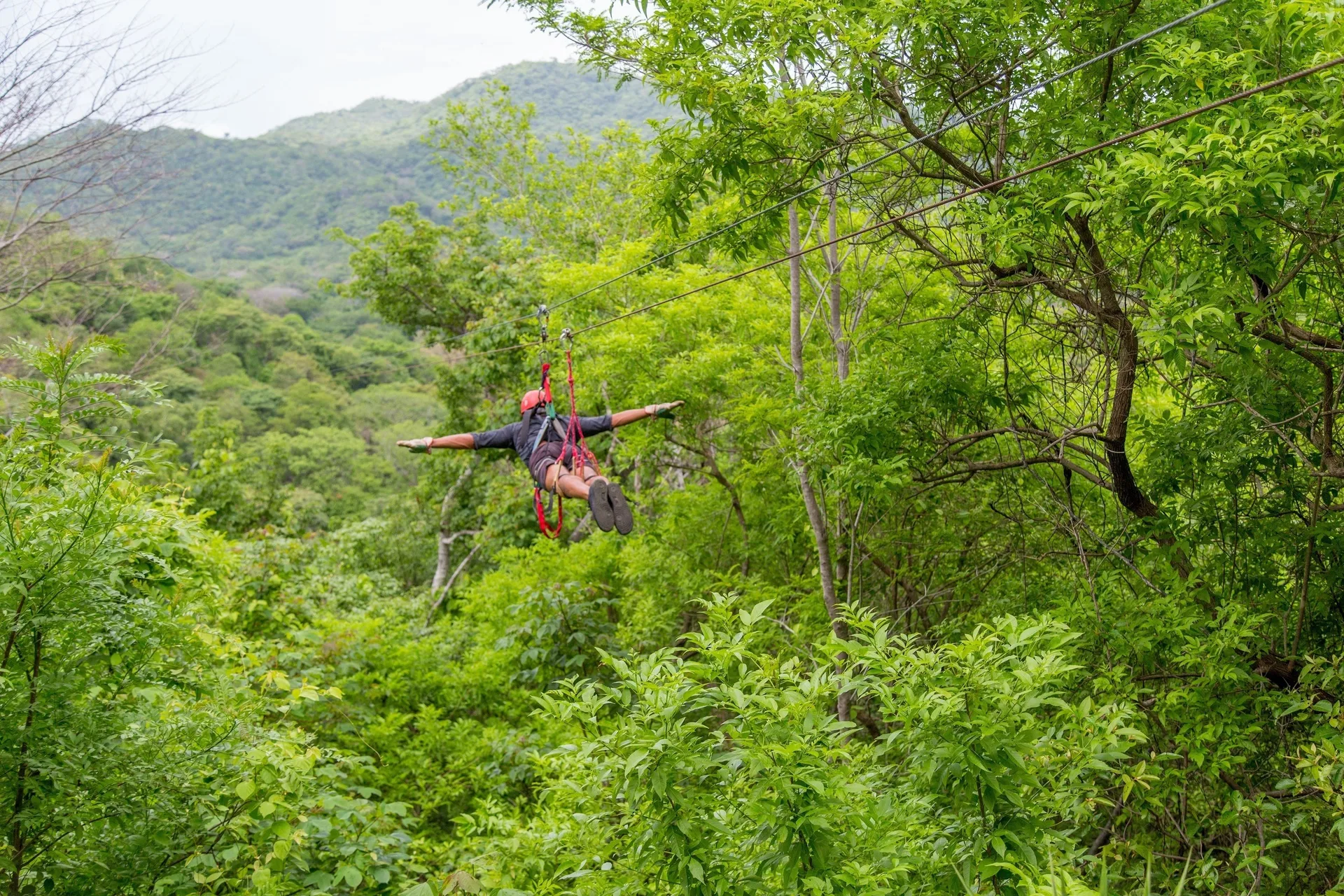 Zipline rider over forest near JW Marriott Guanacaste Resort and Spa.