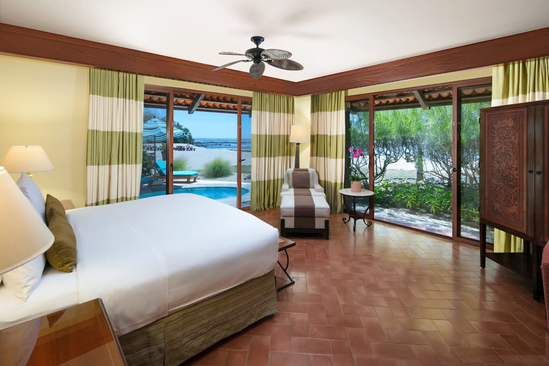 Guest room with king bed and patio pool view at JW Marriott Guanacaste Resort and Spa.