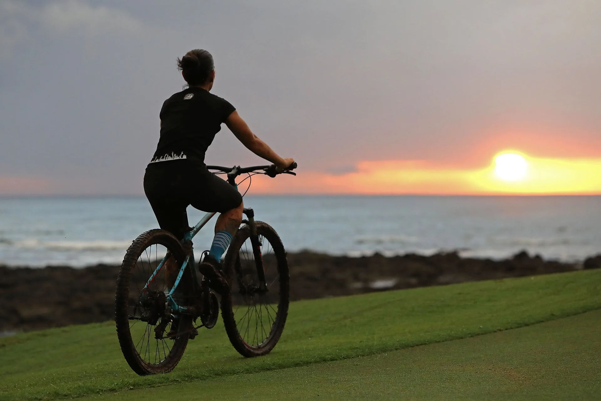 Cyclist riding near the ocean at sunset at JW Marriott Guanacaste Resort and Spa.
