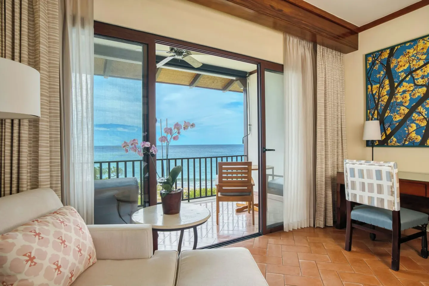 Oceanfront deluxe room sitting area at JW Marriott Guanacaste Resort and Spa with balcony and desk.