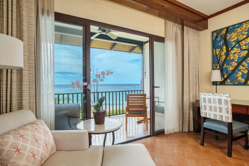 Oceanfront deluxe room sitting area at JW Marriott Guanacaste Resort and Spa with balcony and desk.