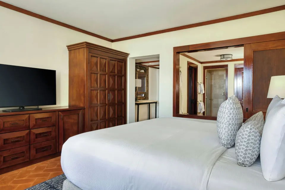 Deluxe Room king bed, TV, and wardrobe at JW Marriott Guanacaste Resort and Spa.