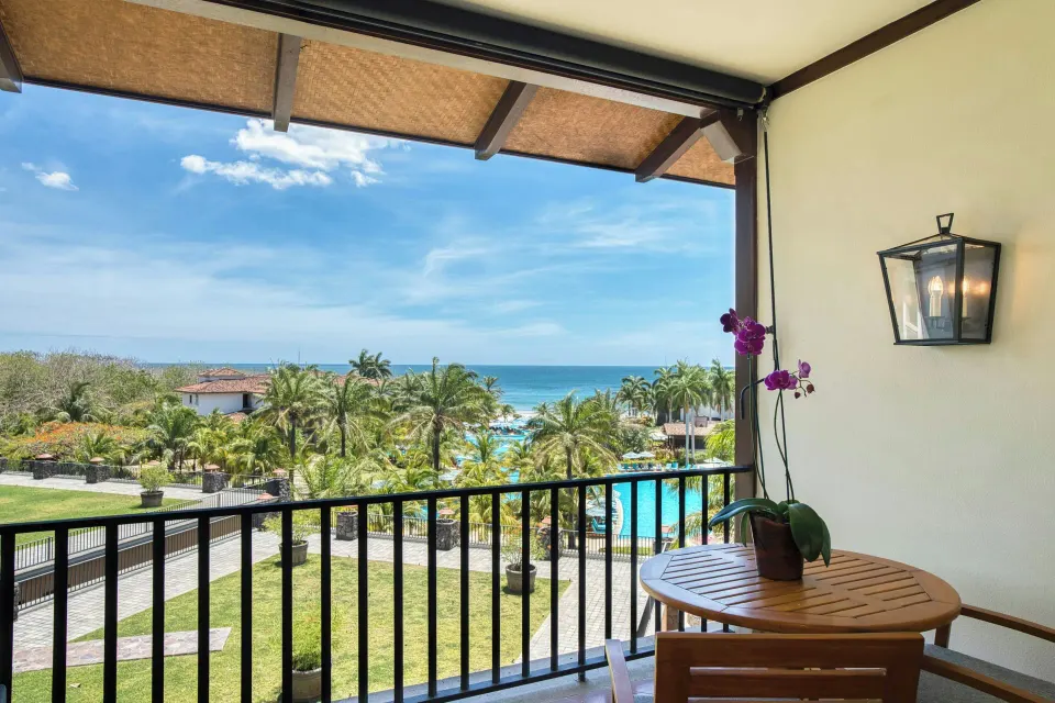 Deluxe Room balcony with ocean, pool, and palm views at JW Marriott Guanacaste Resort and Spa.