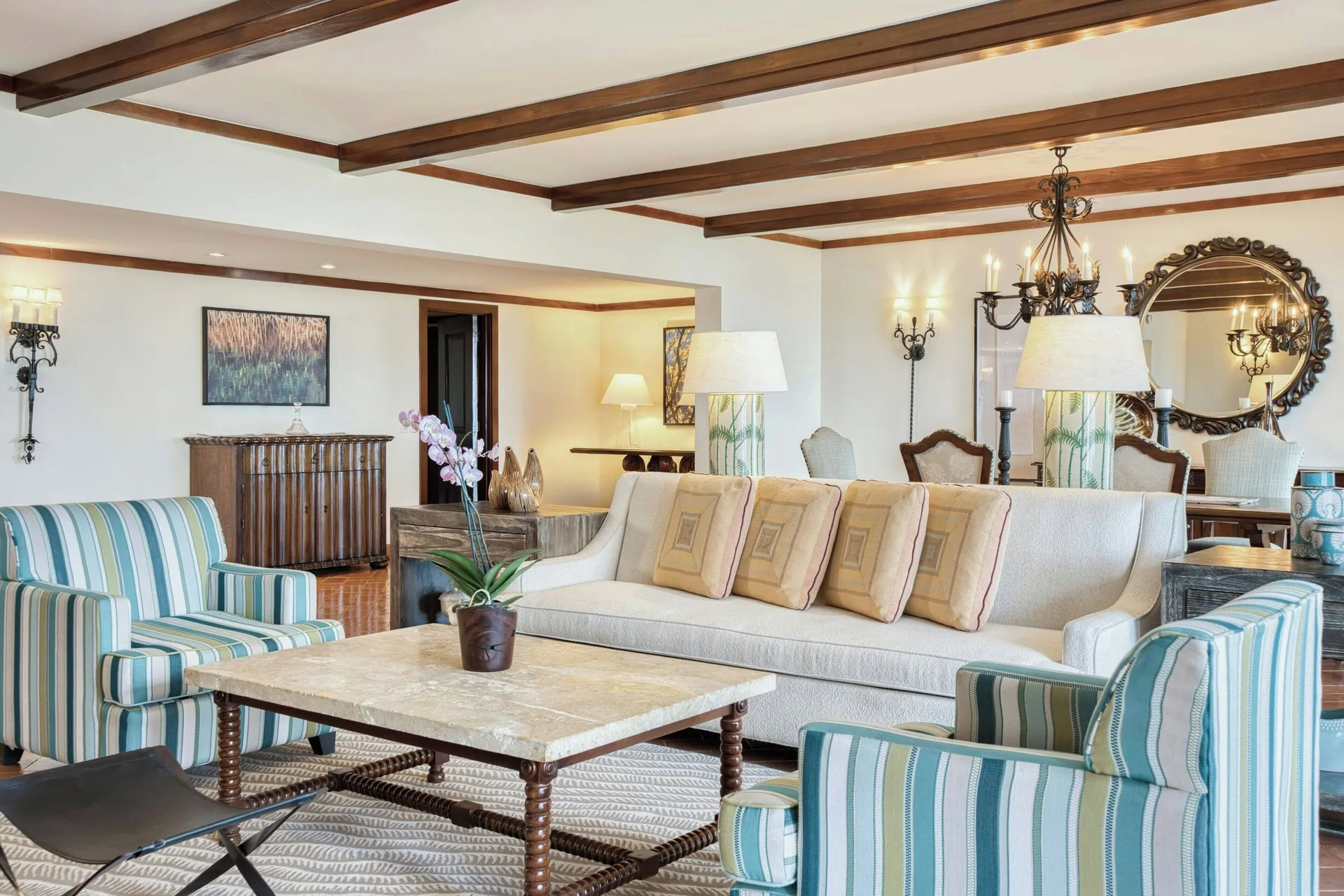 Suite living room with sofa and striped chairs at JW Marriott Guanacaste Resort and Spa.