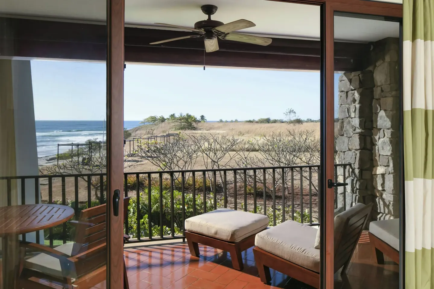 Suite balcony with cushioned chairs and ocean view at JW Marriott Guanacaste Resort and Spa.