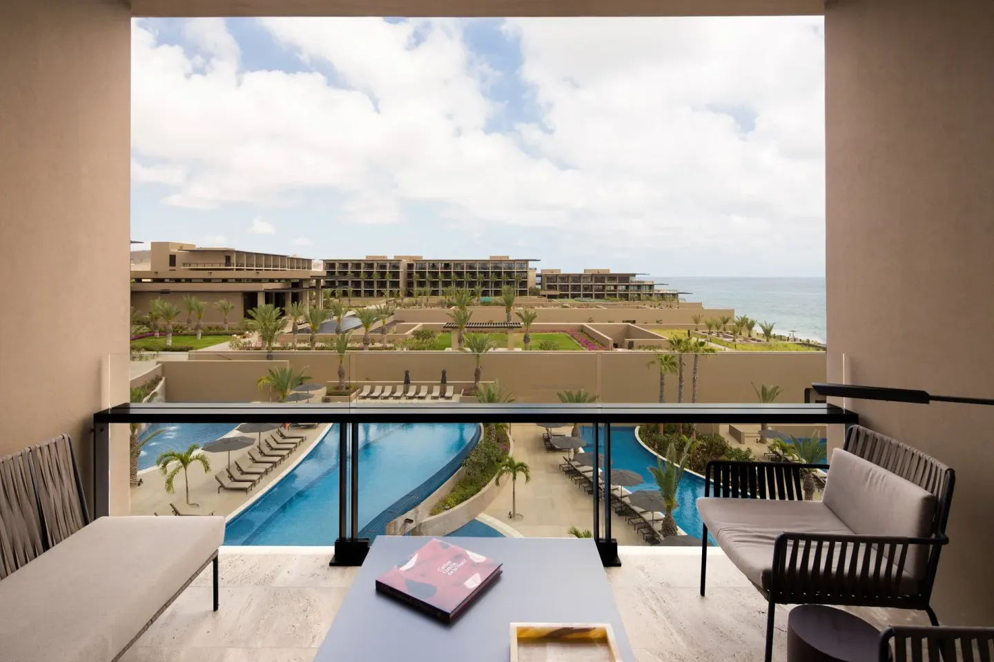 Furnished balcony overlooking pools, lawns and ocean at JW Marriott Los Cabos Beach Resort & Spa.